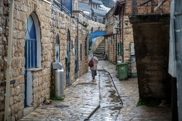 SAFED, ISRAEL - 25 Mart 2022: Güvenli, İsrail 'de dar sokaklar boyunca farklı insanlar yürüyor