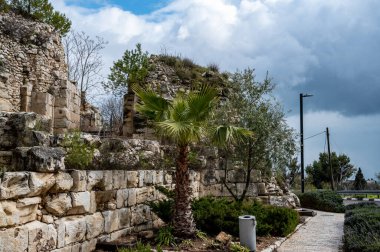 Eski bir duvarın kalıntıları. Eski bir taş işçiliği. Çimlerin üzerinde bir sürü kaldırım taşı var. Kalenin eski kalıntıları. Tarihi konum.