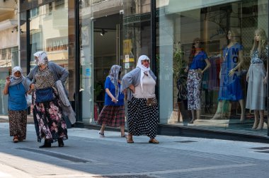 ATHENS, GREECE - MAY 14, 2022: Women in headscarves and masks in the center of Athens, Greece