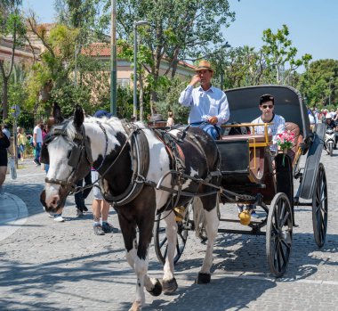 ATHENS, GREECE - MAY 14, 2022: The famous tourist area of Plaka under the Acropolis in Athens, Greece. Horse-drawn carriage ride.