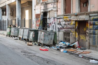 ATHENS, GREECE - MAY 14, 2022: Abandoned building with garbage cans in the center of Athens, Greece