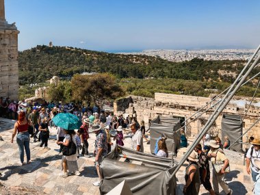 ATHENS, GREECE - MAY 14, 2022: A crowd of tourists storm the Acropolis after its opening. Sunny day.