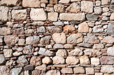 Remains of an ancient stone block wall near the sea in Greece. Sunny day.