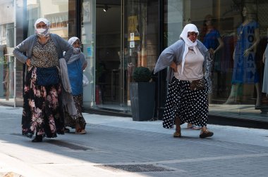 ATHENS, GREECE - MAY 14, 2022: Women in headscarves and masks in the center of Athens, Greece