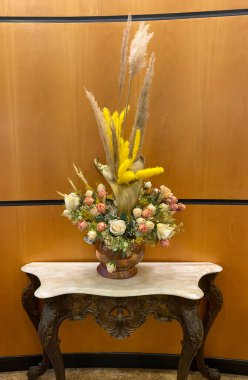 Bir buket kuru gül, eski bir masanın üstünde vazoda dikenler ve paniklemeler. İç güvenlik. Retro biçimi.