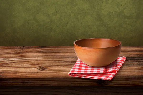 Tablecloths and soup bowl over wooden table — Stock Photo, Image