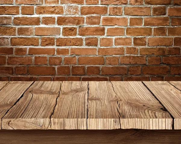 Wooden table and brick background — Stock Photo, Image