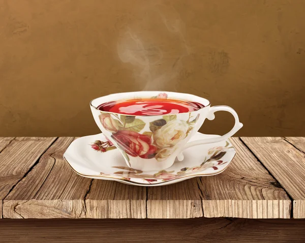 Porcelán teáscsésze Vágógörbe fából készült asztal fölött — Stock Fotó