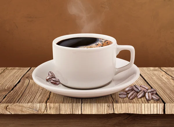 Чашка кави над дерев'яним столом з відсічним контуром — стокове фото