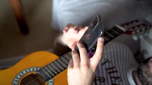 Vista Superior Hombre Con Guitarra Acostado Sofá Usando Teléfono — Vídeo de stock