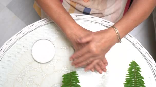Starsza Kobieta Nakłada Krem Nawilżający Ręce Jasnym Pomieszczeniu Roślinami Domu — Wideo stockowe