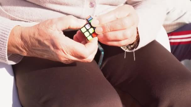 Senior Woman Solving Rubik Cube Improve Memory Mental Abilities Outdoor — 图库视频影像