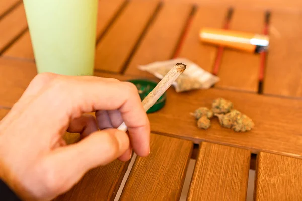 Vista Primera Persona Mano Sosteniendo Porro Marihuana Una Mesa Con — Foto de Stock