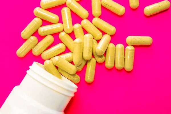 핑크 배경에 약을 쏟아 놓은 하얀 병, 의학 개념 — 스톡 사진