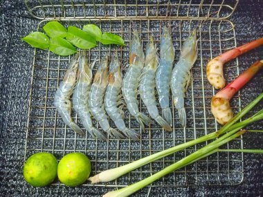 Paslanmaz çelik ızgarada taze karides. Kefir limon yaprakları, limon otu, limon, galangal.