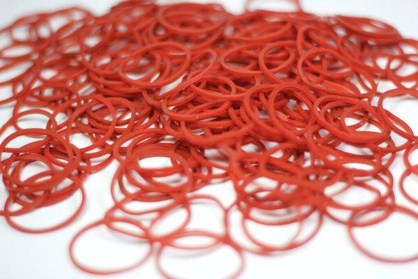 красные резинки, сложенные вместе на белом фоне