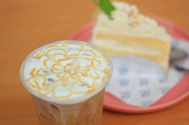 Drink: Iced Caramel Macchiato Decorated with milk foam and caramel topping.
