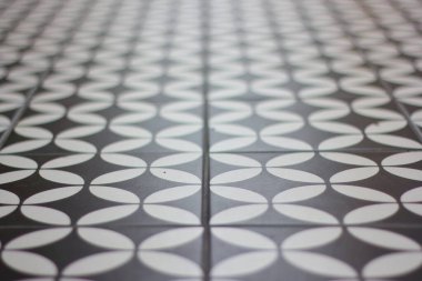 Tiled floor with alternating curves, black and white.