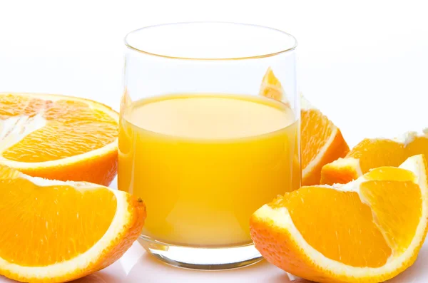 Ett glas apelsinjuice med orange inkvarterar — Stockfoto