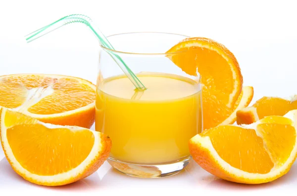 A glass of orange juice with orange quarters — Stock Photo, Image