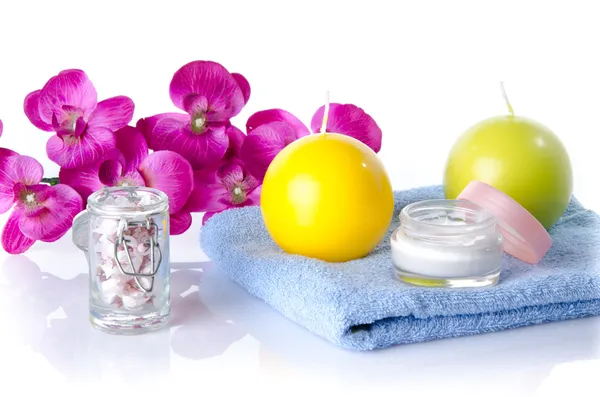 Moisturizing cream with candles and flower on a towel — Stock Photo, Image