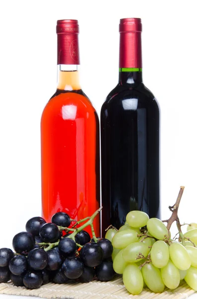 Bootles of wine with black and white grapes — Stock Photo, Image