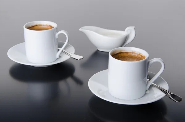 Två koppar kaffe med en mjölkkanna — Stockfoto