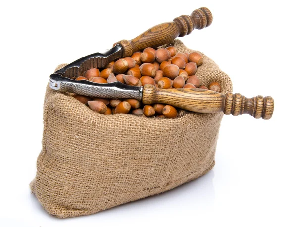 Hazelnuts in a burlap bag with a nutcracker — Stock Photo, Image