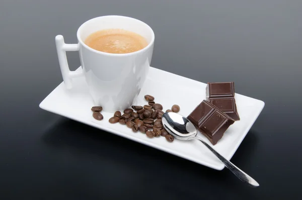 Una tazza di caffè con cioccolato e chicchi di caffè — Foto Stock