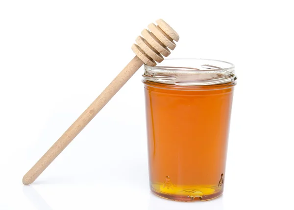 Jar of honey with a honey dipper — Stock Photo, Image