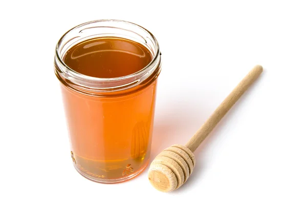 Jar of honey with a honey dipper — Stock Photo, Image