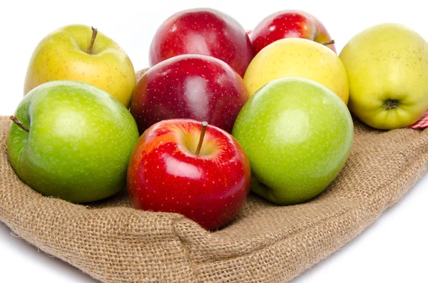 Quatre sortes de pommes sur un sac en toile de jute — Photo
