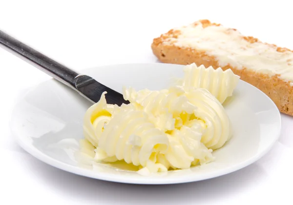 Plate of butter with a buttered crisp toast — Stock Photo, Image