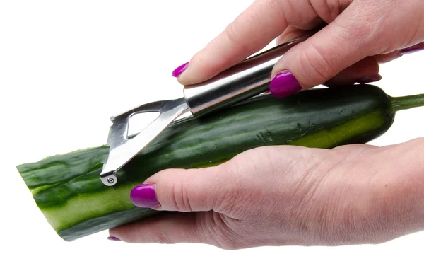 Vrouw hand peeling een komkommer — Stockfoto