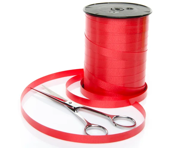 Rolka błyszczące czerwone wstążki prezent z nożyczkami — Zdjęcie stockowe