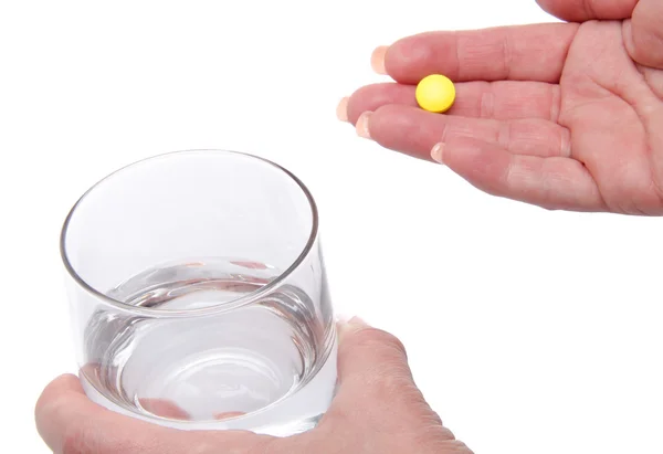 Mains tenant une pilule et un verre d'eau — Photo