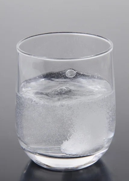 Effervescent tablet in a glass of water — Stock Photo, Image