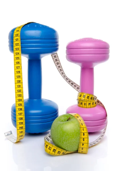 Dumbells and an apple with a tape measure — Stock Photo, Image