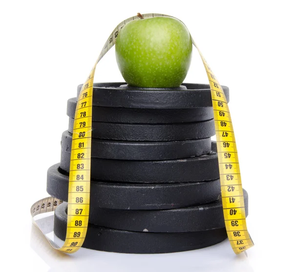 Яблоко на весах с рулеткой — стоковое фото