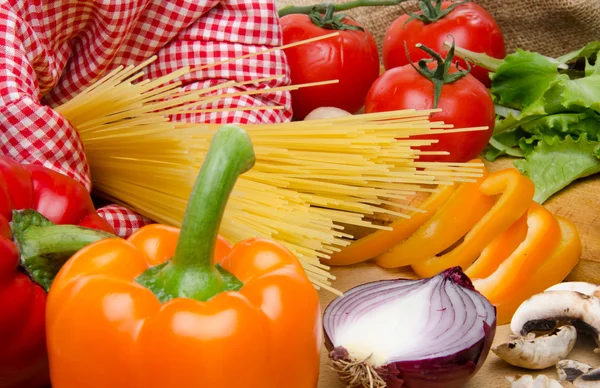 Samenstelling van ongekookte spaghetti omringd door groenten — Stockfoto