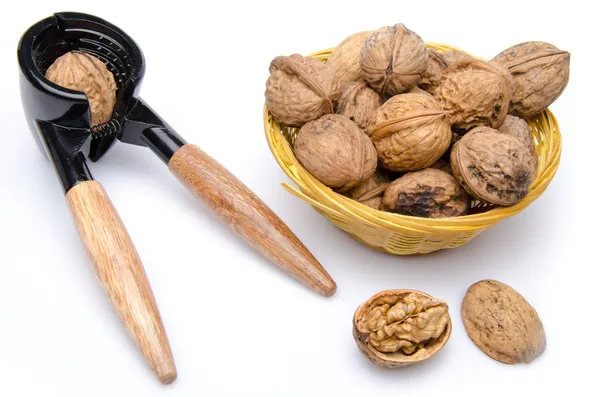 Walnuts in a basket with a nutcracker — Stock Photo, Image