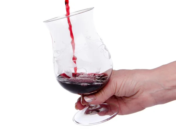 Hand holding a glass in which wine is poured — Stock Photo, Image