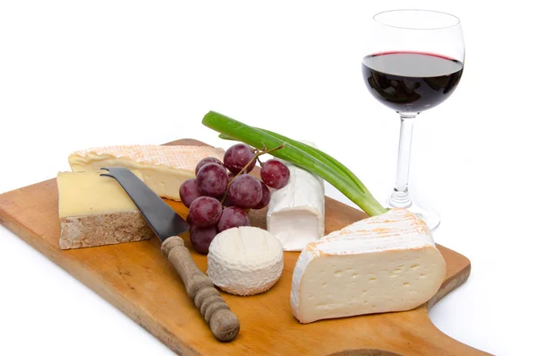 Composition of different cheeses on a wooden cutting board — Stock Photo, Image