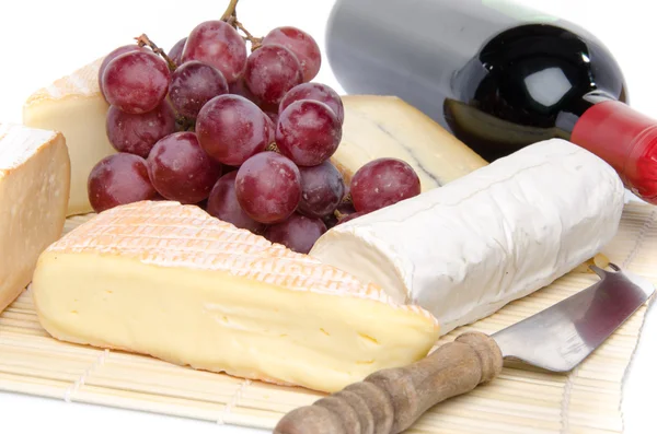 Composition of different cheeses on a straw placemat — Stock Photo, Image