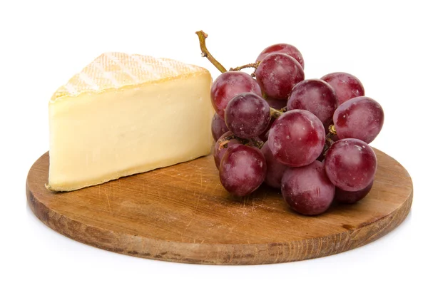 Cheese with grapes on a wooden board — Stock Photo, Image