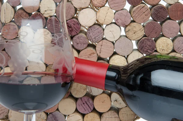Μπουκάλι και το ποτήρι του κρασιού σε φόντο των φελλών — Φωτογραφία Αρχείου