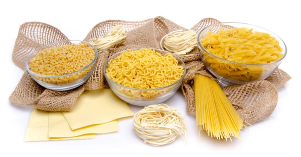 Different types of uncooked pasta on a burlap — Stock Photo, Image