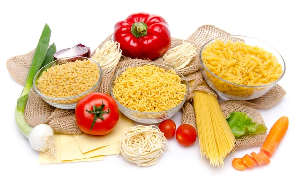 Diferentes tipos de pasta y verduras sin cocer en una arpillera —  Fotos de Stock