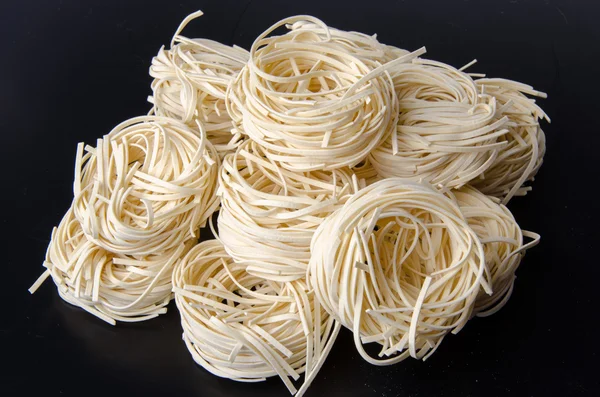 Mound of uncooked italian pasta tagliatelle nests — Stock Photo, Image