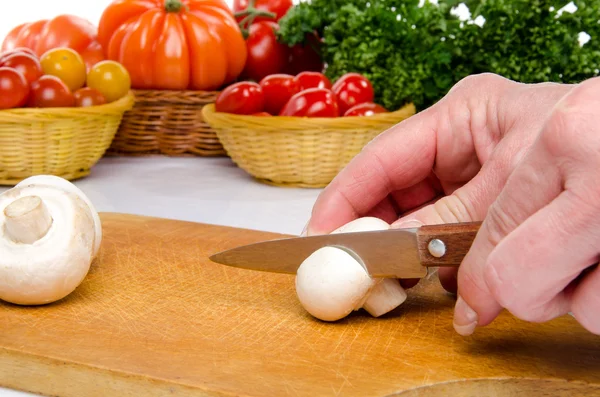 Hand cutting a mushroom — Stock Photo, Image